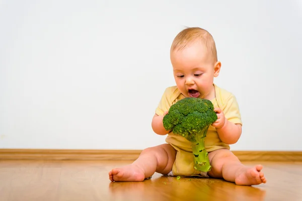 Bebê comendo brócolis — Fotografia de Stock