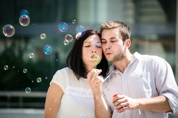 Casal se divertir com o ventilador de bolhas — Fotografia de Stock