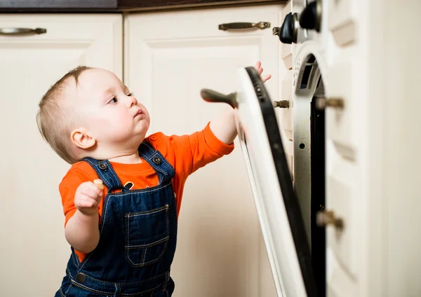 Bebé viendo horno de cocina interior —  Fotos de Stock