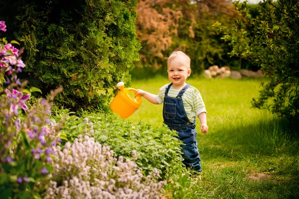 Growing plants - baby with watering can — Stock Photo, Image