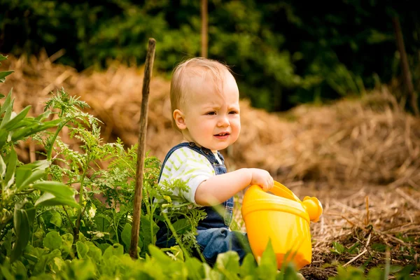 Growing plants - baby with watering can — Stock Photo, Image