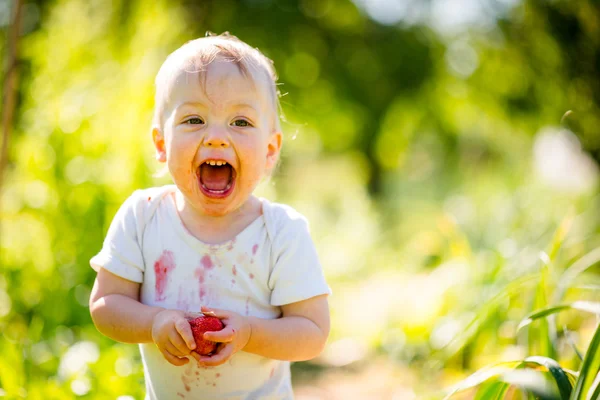 Bebê feliz com morango — Fotografia de Stock