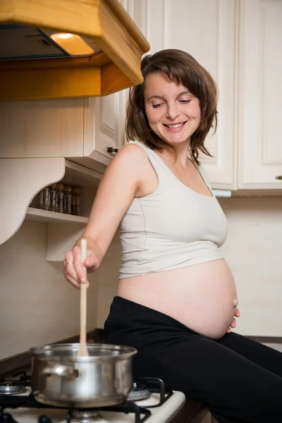 Pregnant woman cooking — Stock Photo, Image