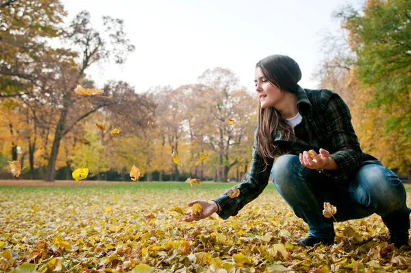 Vida feliz - mulher jogando folhas no outono — Fotografia de Stock