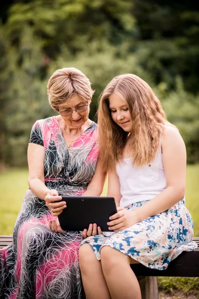 Barnbarn visar mormor tablet — Stockfoto