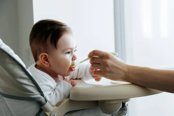 Ritratto di un bambino dolce, nutrito con cibo per bambini da un cucchiaio — Foto Stock