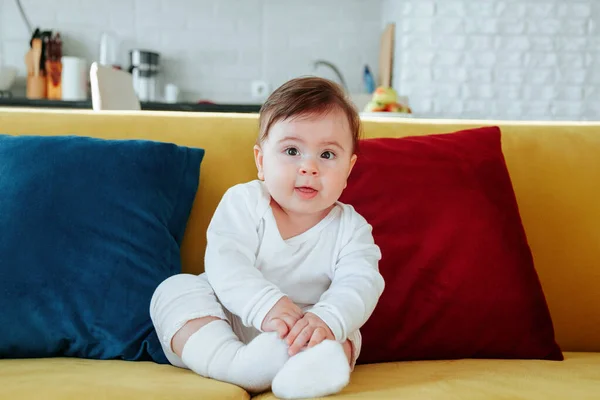 Carino bambino seduto sul divano colorato in soggiorno — Foto Stock