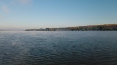 İHA 'lar neredeyse sisli bir gölün sularında uçuyor.,