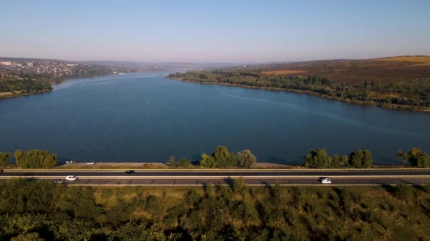 Der Flug der Drohne über eine Autobahn mit fahrenden Autos und einem See in den Vororten, — Stockvideo