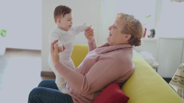 Abuela con su lindo bebé nieta, sonriendo, hablando, jugando — Vídeos de Stock