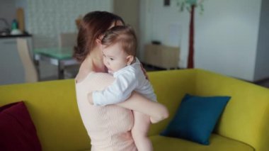 Sevgi dolu beyaz Avrupalı genç bir anne kucağında sevimli bir kız bebek