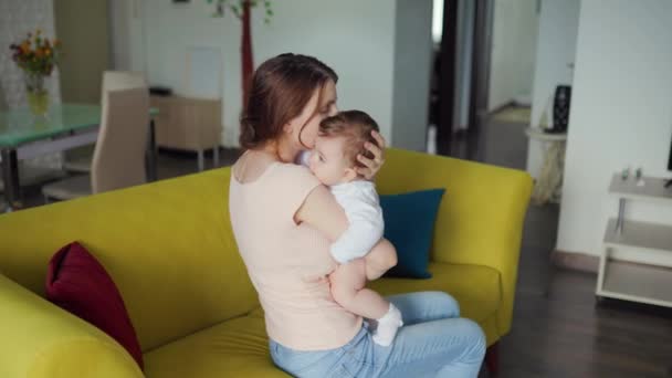 Jong moeder en haar baby, vrouw knuffelt haar kind of schattig klein meisje. — Stockvideo