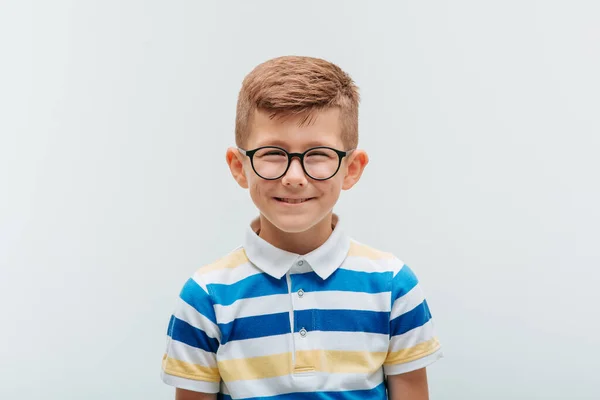 Das Porträt eines fröhlichen Jungen mit Brille, der vor der Kamera lächelt. — Stockfoto