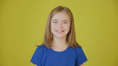 Mutlu ve güzel kız kameraya bakıyor ve gülümsüyor..