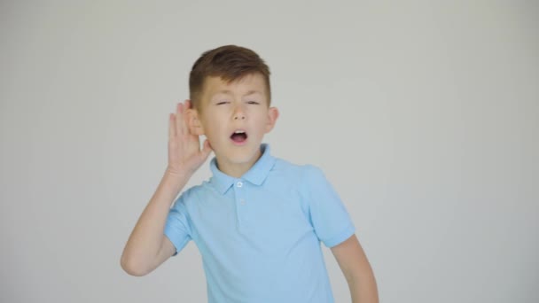 Curious little caucasian boy holding hand near ear and overhearing gossips — Stock Video