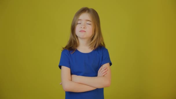 Verärgertes Kind mit gekreuzten Händen auf gelbem Hintergrund im Studio — Stockvideo