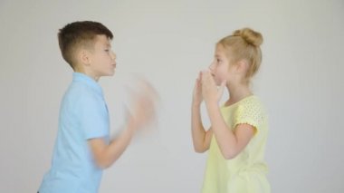 İki çocuk tartışıyor, kız ve oğlan elleriyle tartışıyor ve el kol hareketi yapıyorlar.,
