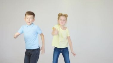 Stüdyoda dans eden iki neşeli çocuk yüzü ve çocuk, beyaz bir arka planda