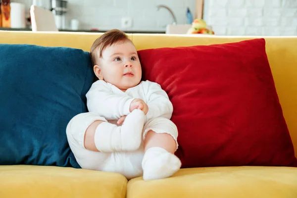 Carino bambino seduto sul divano colorato in soggiorno — Foto Stock
