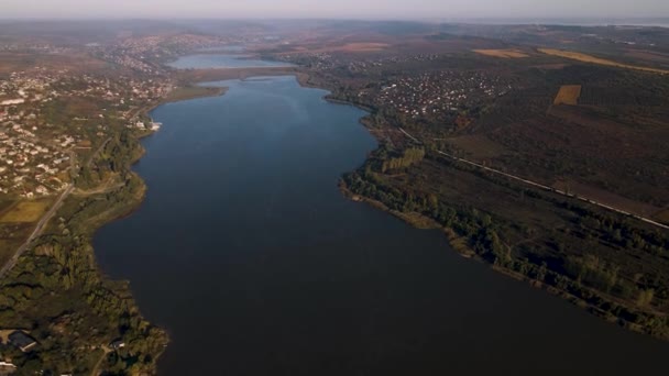 O voo drones sobre um belo lago com aldeias e terras agrícolas — Vídeo de Stock