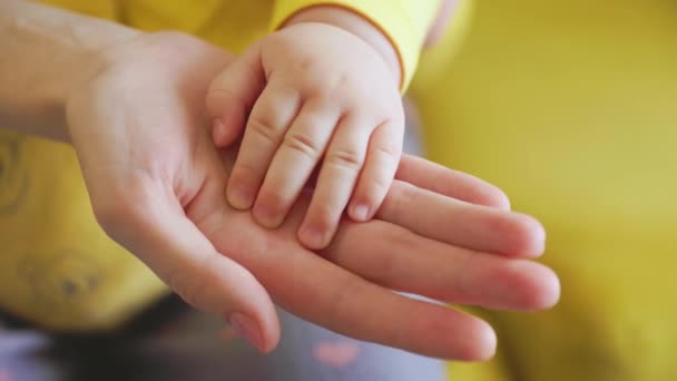 Close-up van baby aanraken moeders hand. — Stockvideo