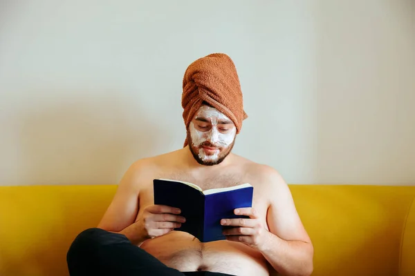 Rolig man med ansiktsmask, läser en bok — Stockfoto