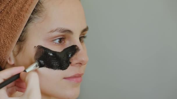 Gros plan d'une application du masque cosmétique sur le visage des femmes — Video