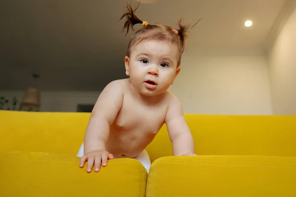 Carina bambina, sul divano giallo di casa in soggiorno — Foto Stock