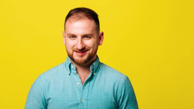 Neşeli, kaygısız genç adam kameraya bakıyor ve gülümsüyor..
