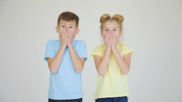 Twee verbaasde kinderen geschokt met hun handen in hun mond, — Stockvideo