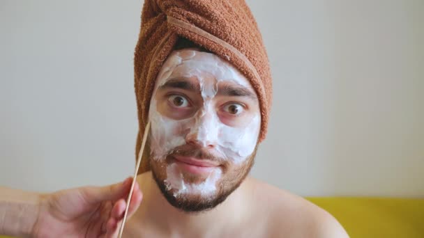 Cosmetologist applies mask with spatula on face of man — Stock Video