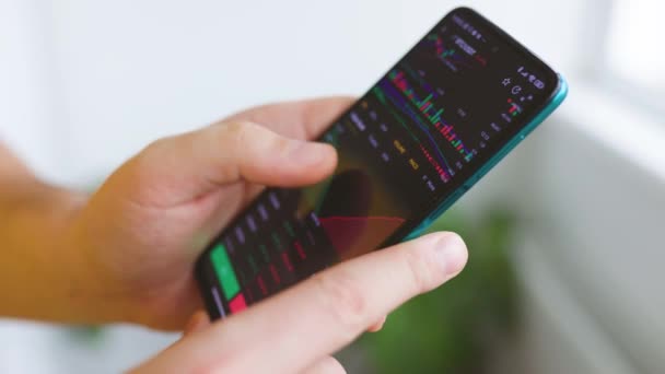 Feche o dedo do empresário trabalhando com o gráfico de dados do mercado de ações em um smartphone — Vídeo de Stock
