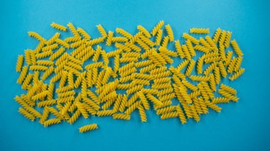 Mavi arkaplan, üst görünüm ve yemek arkaplanındaki Fusilli spiral macunu,