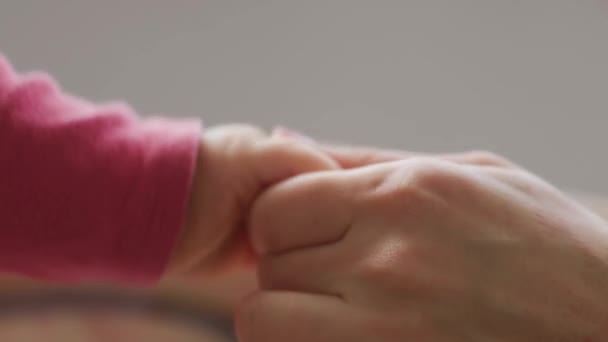 Nahaufnahme eines neugeborenen Babys, das den Finger eines Elternteils hält — Stockvideo