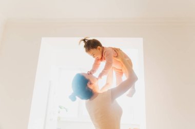 Mutlu bir anne sabah mutlu bir bebekle oynar ve kaldırır.