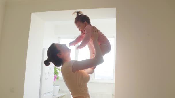 Mãe feliz levantando e brincando com um bebê satisfeito pela manhã, — Vídeo de Stock