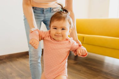 Mutlu bebeklerin yüz ifadelerine yakından bakın. Yürümeyi öğrenen çocuk ilk adımlarını atıyor.