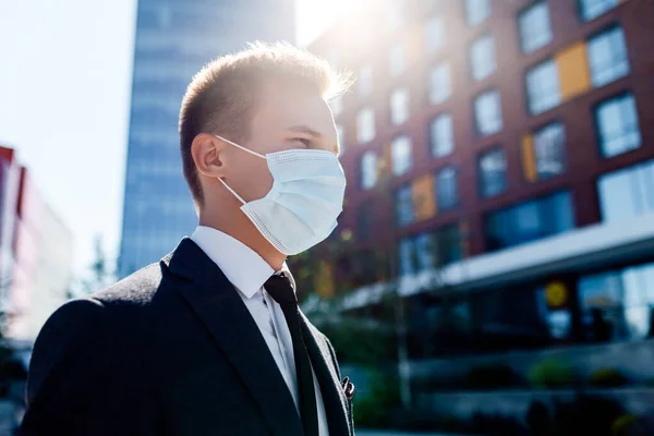 Zakenman en coronavirus epidemie. Close up portret van jonge zakenman in een wegwerp gezichtsmasker — Stockfoto