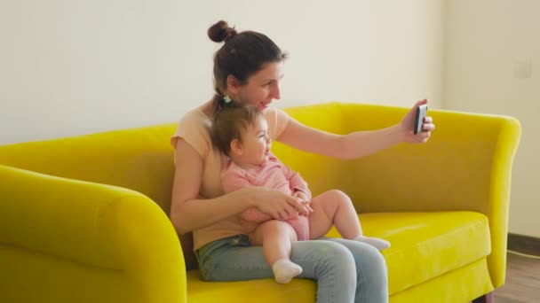 Молодая счастливая мать и ребенок, имеющие видео-чат с отцом с помощью смартфона — стоковое видео
