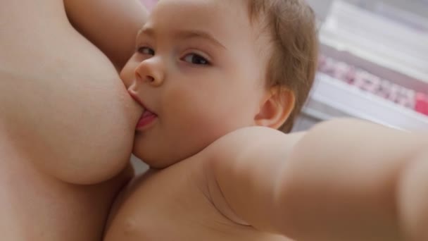 Primer plano de una joven madre amamantando a su pequeño bebé — Vídeos de Stock