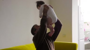 Büyükannem ve büyükbabam kanepede oturuyor Bebekle oynuyorlar.