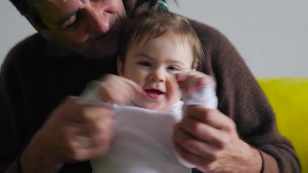 Счастливый дедушка держит ребенка на руках и говорит — стоковое видео