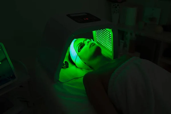 미용실에서 자외선 LED 빛 얼굴 치료를 받고 있는 여성. — 스톡 사진