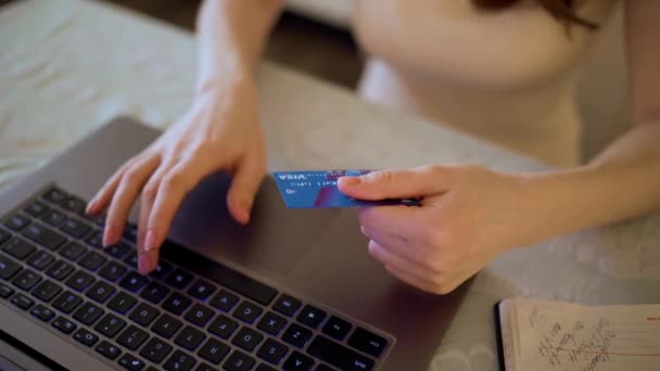 Закрыть женскую руку с помощью кредитной карты на ноутбуке дома. — стоковое видео