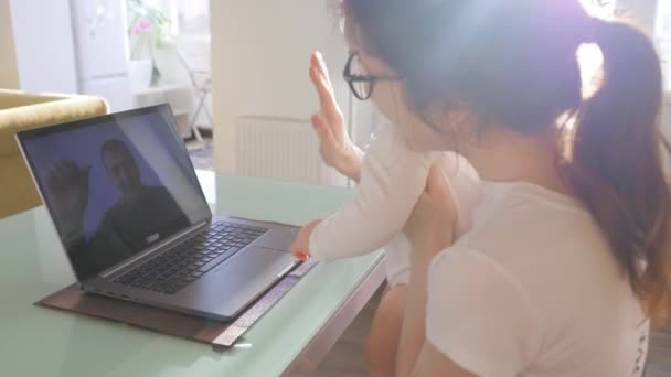 Mutter und ihre kleine Tochter sprechen mit Opa Videotelefonie mit Laptop. — Stockvideo