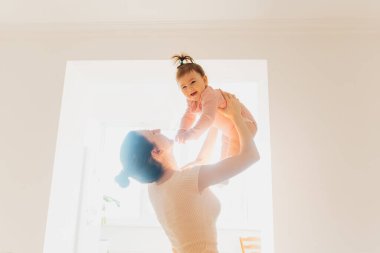 Mutlu bir anne sabah mutlu bir bebekle oynar ve kaldırır.