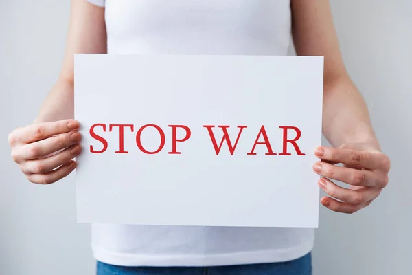 Close up of a Protester hands holding cardboard Banner with the words stop war protesting against the Russian invasion. — Stock fotografie