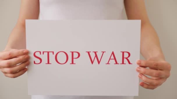Großaufnahme eines Demonstranten, der ein Pappbanner mit der Aufschrift "Kein Krieg" in den Händen hält — Stockvideo