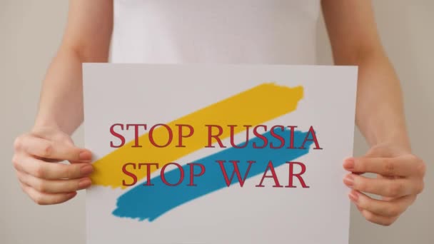 Mains tient une affiche avec l'image du drapeau ukrainien, qui dit arrêter la guerre arrêter la Russie — Video