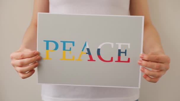 Close up de um protestante mãos segurando banner de papelão com as palavras paz — Vídeo de Stock